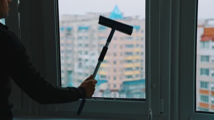 工人洗塑料窗。男人在城市的高楼里用刷子清洁窗户。洗玻璃窗。