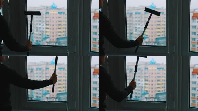 工人洗塑料窗。男人在城市的高楼里用刷子清洁窗户。洗玻璃窗。