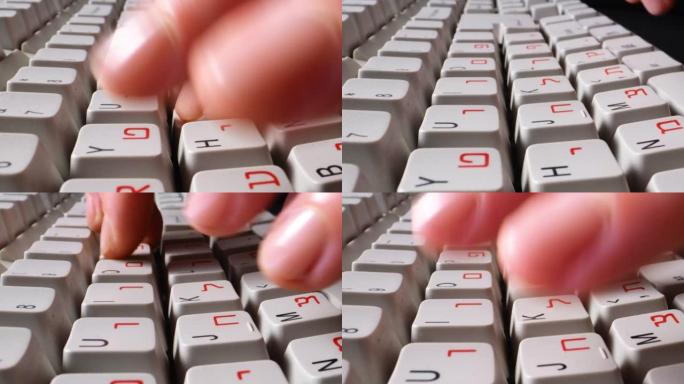 用英语和希伯来语字母在计算机键盘上打字的手指