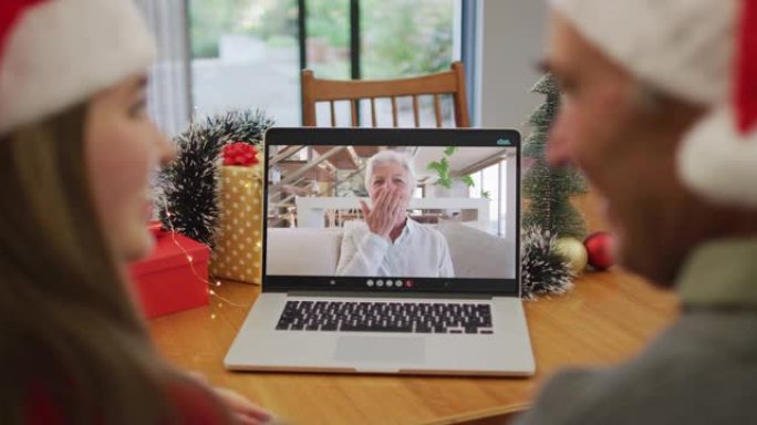 快乐的高加索老人和孙女在圣诞节与祖母进行视频通话