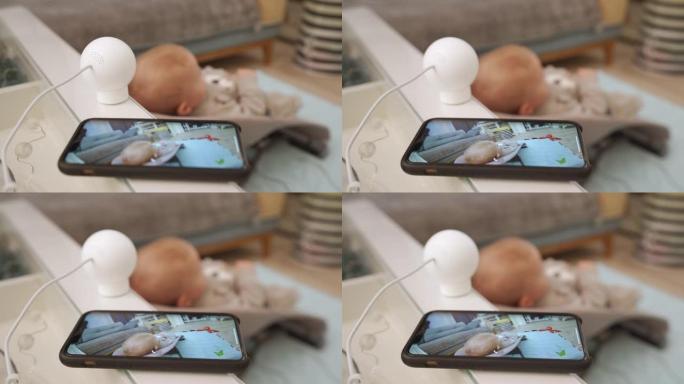 家庭安全摄像头在客厅工作，使用ip摄像头作为手机上的婴儿视频监视器，在智能手机屏幕上观看直播。