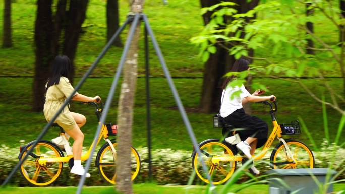 两位小姐姐骑共享单车逛公园