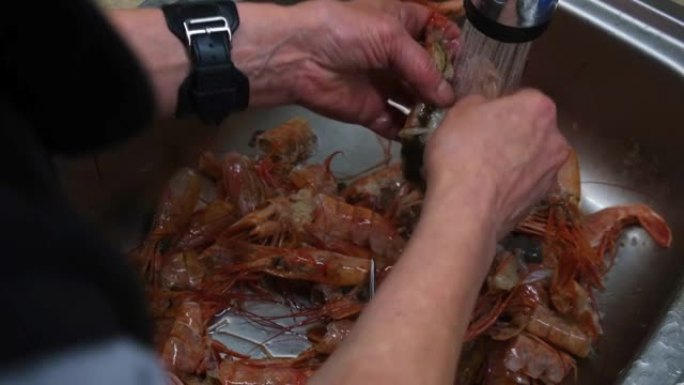 4k。用厨房水槽里的专业剪刀从外壳上清洁海螯虾和老虎或大虾。烹饪概念烹饪前准备海鲜，虾。海鲜产品。