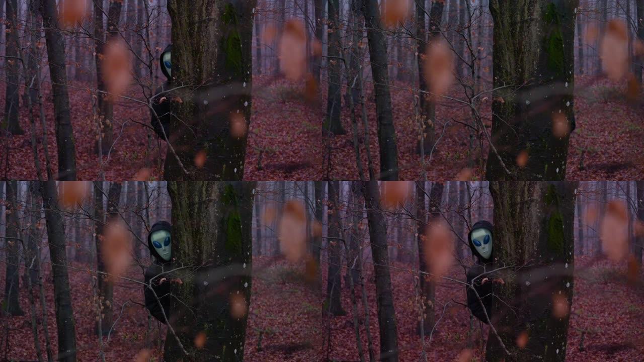 外星面具中的生物从森林中的树干后面窥视