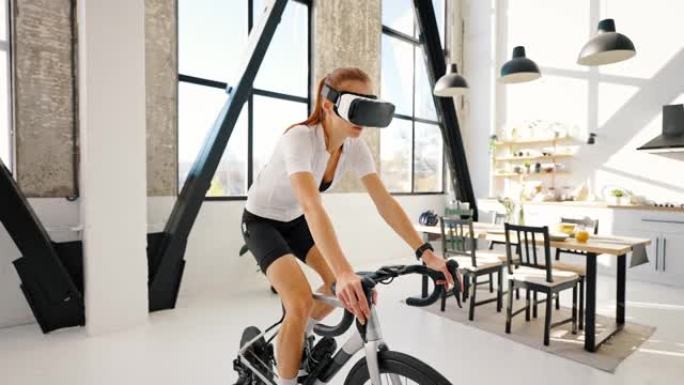 戴VR眼镜的年轻女性正在踩着室内健身车教练。工作室公寓，厨房。在家进行日常训练。慢动作