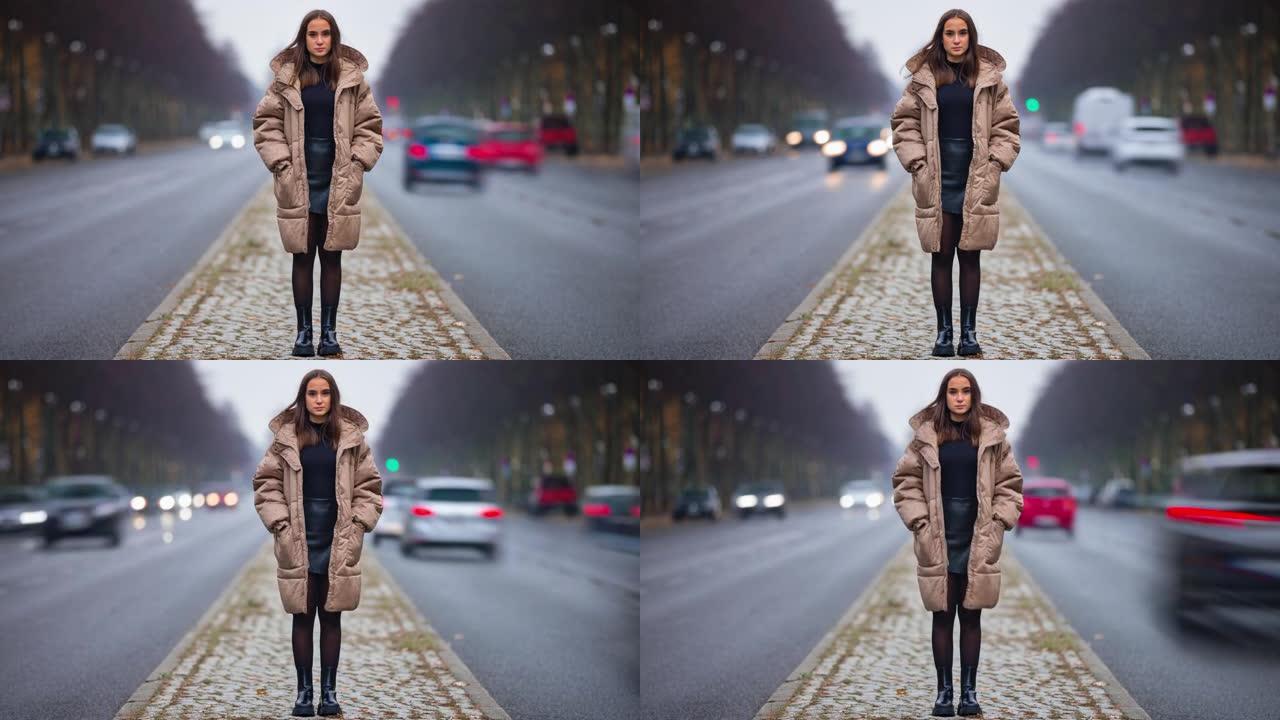 秋日站在城市街道上的年轻女子独自看着相机的时间流逝。现代生活方式、人和社会观念。
