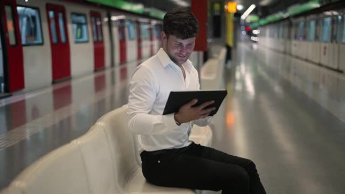 高兴的商人在地铁中使用平板电脑