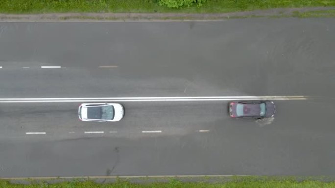 大雨过后，汽车在洪水泛滥的街道上行驶的城市交通鸟瞰图。道路排水系统存在的问题