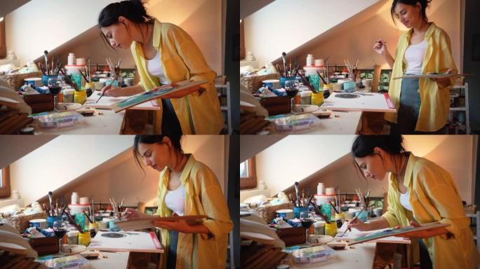 在她舒适的艺术工作室里，快乐的女艺术家在画布上绘画