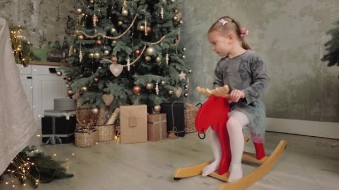 节日快乐，小女孩在圣诞树附近玩耍