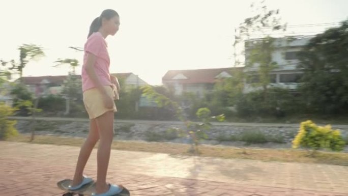 快乐的亚洲儿童骑自行车和滑板一起在傍晚的道路上晒太阳，健康的生活方式理念。