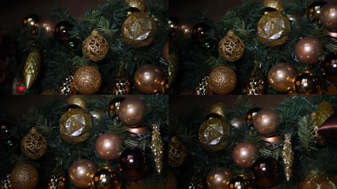 金色圣诞树玩具球挂在带有花环的圣诞树上