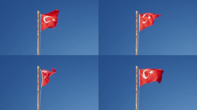 土耳其国旗在蓝天下迎风飘扬。旗杆上飘扬的红色土耳其国旗。土耳其国旗和标志