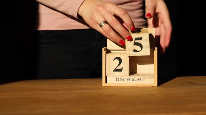 女人换手，在12月25日的木制日历上设定日期