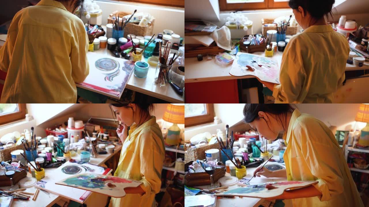专注而有才华的女人，在她的艺术工作室在画布上绘画