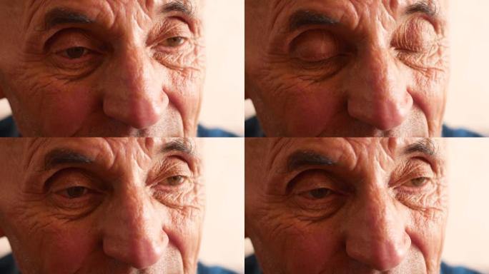 一位70岁以上白人老人的肖像。脸上有深深的皱纹的沉思老人。选择性聚焦。老人经常眨眼睛专心听