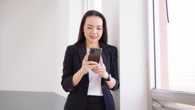使用数字媒体，技术，社交媒体的概念在线浏览世界亚洲女商人的手使用智能手机发送电子邮件或使用社交媒体通