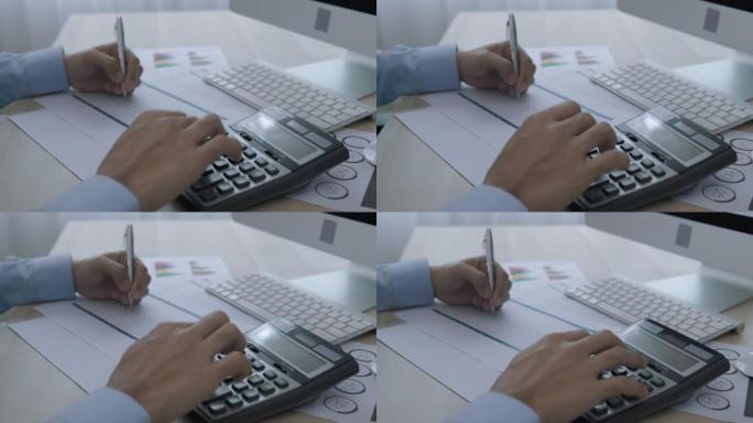 忙碌的商人使用笔记本电脑和计算器来准备预测的预算。
