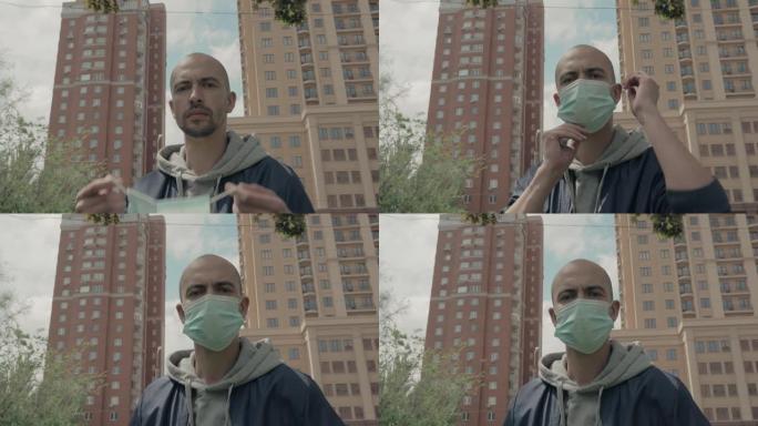 一个站在大城市的男人在脸上戴上医用口罩。