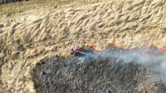 旱季消防员扑灭用红火燃烧的草地的鸟瞰图。自然灾害与气候变化概念