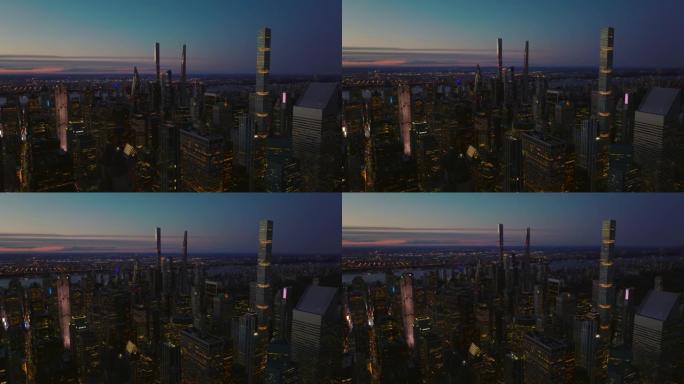 市区傍晚的上升镜头。现代高层建筑，日落之后有亮光的窗户和五彩缤纷的天空。美国纽约市曼哈顿