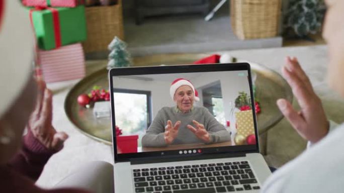 多元化的资深女性朋友使用笔记本电脑与屏幕上的男人进行圣诞节视频通话