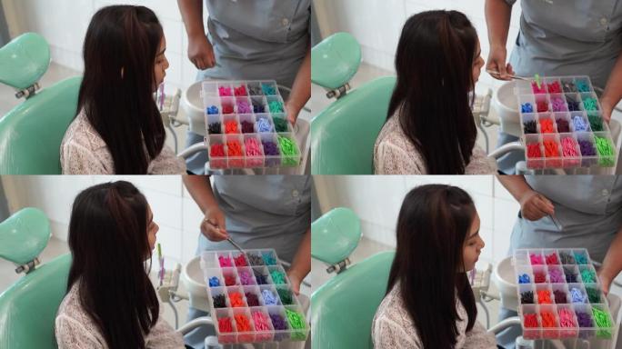 亚洲妇女选择橡胶支架与助理牙医在牙科诊所，正畸治疗。