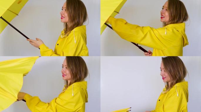 穿黄色雨衣的女孩把伞折起来。孤立在白色背景上