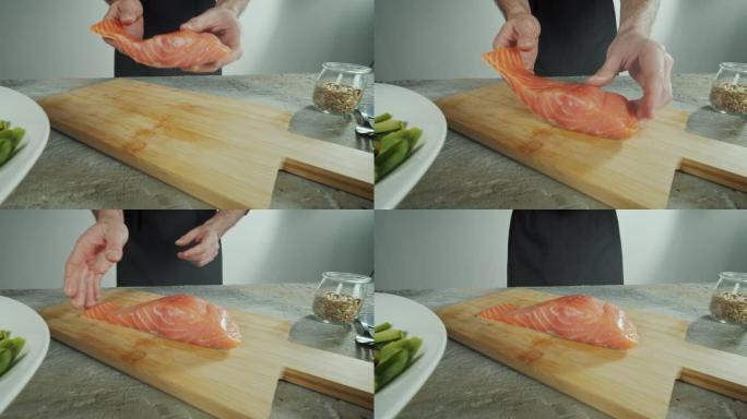 厨师把一条鱼放在木板上切片。特写