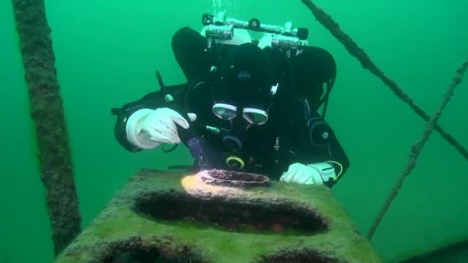 技术潜水员检查淡水沉船上的木炉