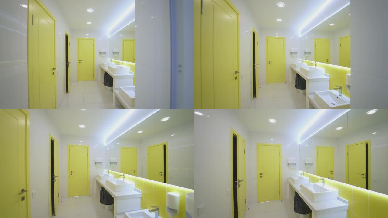 白色和黄色的洗手间。医院里有干净水槽的现代抽水马桶。无菌盥洗室内部。