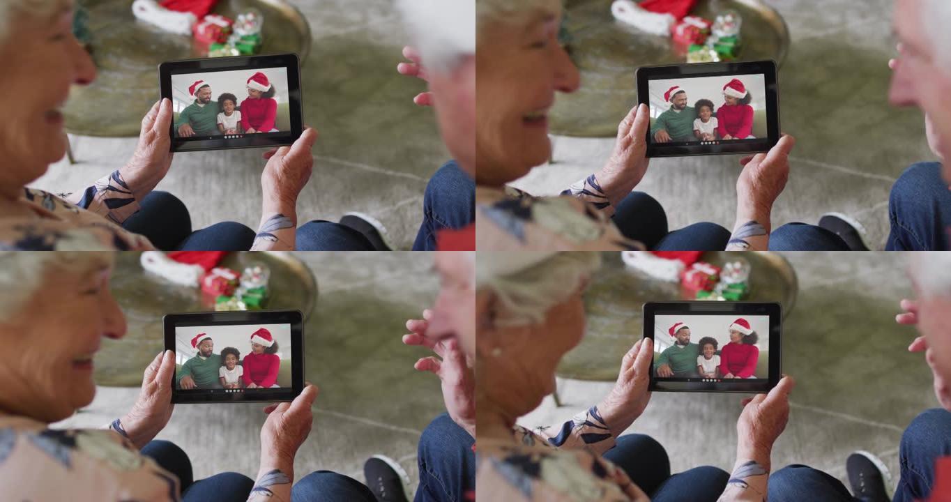 高级高加索夫妇使用平板电脑与屏幕上的幸福家庭进行圣诞节视频通话