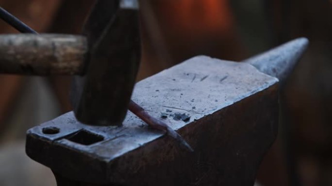 铁匠父子用锤子在铁砧上锻造热钢。为弓制作箭头