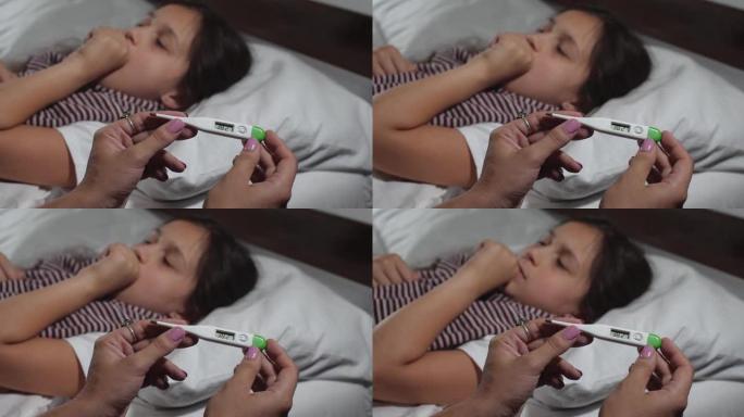 9岁小女孩的特写镜头感冒躺在床上患流感。小孩咳嗽和打喷嚏，母亲的手测量她的高温。4K