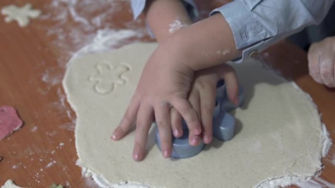 妈妈和宝宝做姜饼的手的特写。在圣诞节和新年，一家人一起呆在家里。