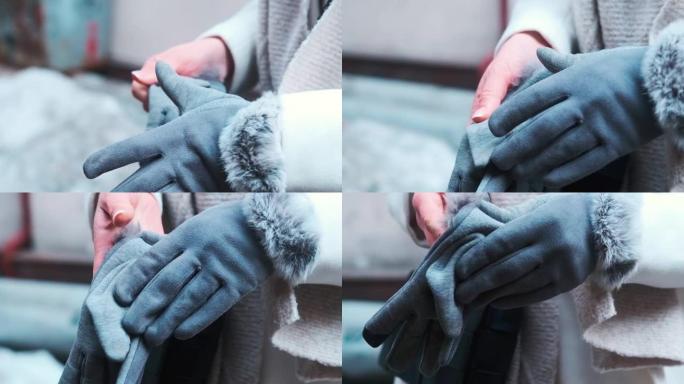女孩戴上灰色手套。特写