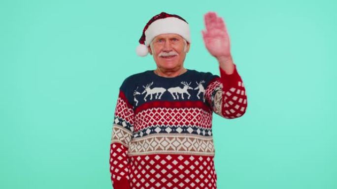穿着圣诞毛衣的祖父男人带着deers挥手打招呼的手掌欢迎某人