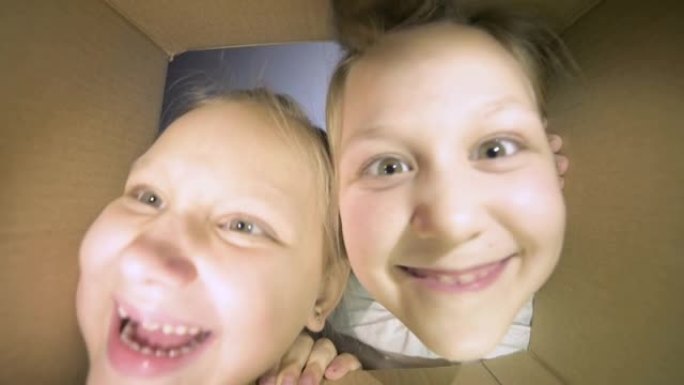 两个迷人的小女孩开心地打开盒子，试着深入研究它。在礼物开始之前，有礼物和期待的乐趣和游戏