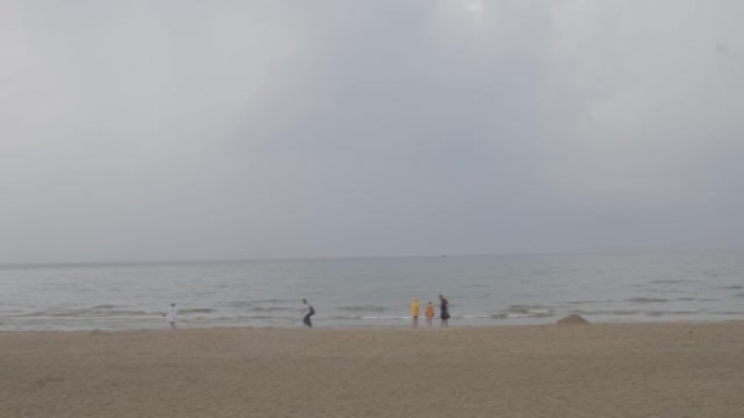 沙滩。人们走在沙滩上，看着大海。