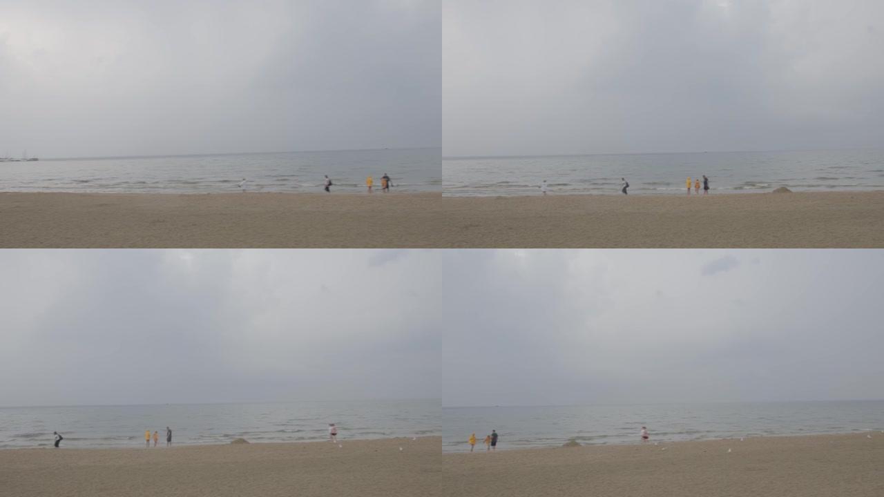 沙滩。人们走在沙滩上，看着大海。