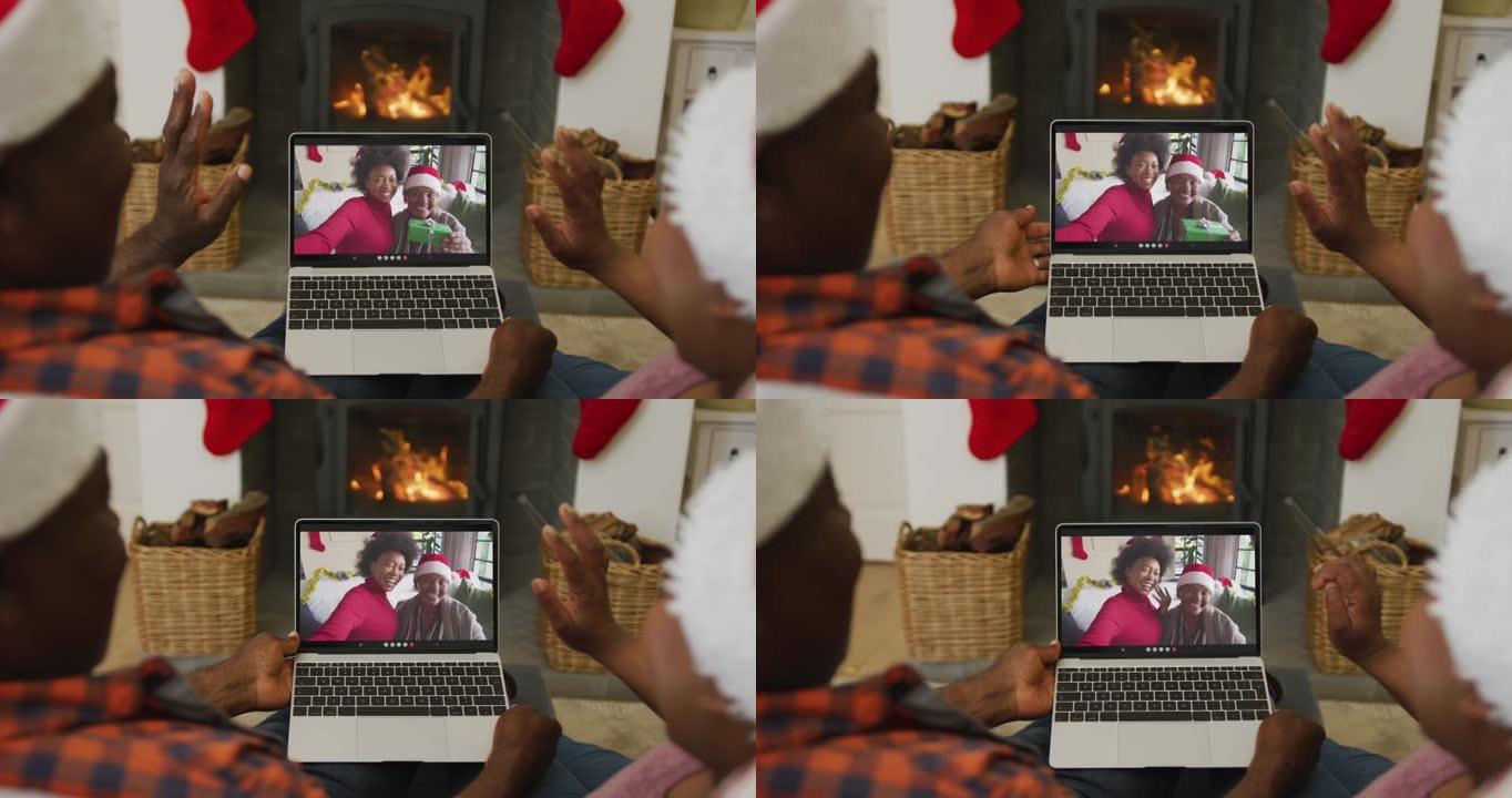戴着圣诞老人帽子的非裔美国人夫妇使用笔记本电脑与家人在屏幕上进行圣诞节视频通话