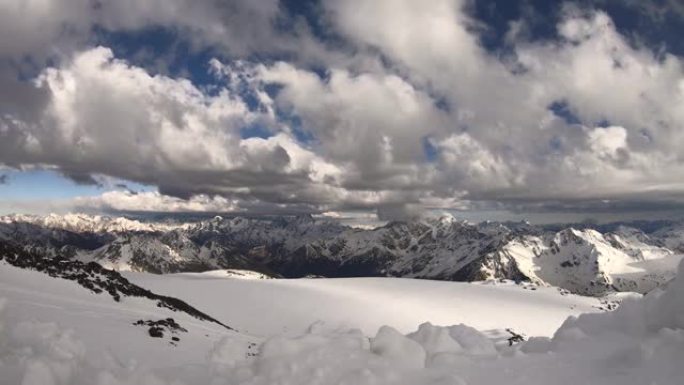 从4000米高高的雪山岩石的高度延迟，冰川和高加索主岭的山脉，傍晚的日落橙色云和山顶上的冰川。