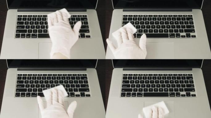 男人的手握住并捕捉消毒剂喷雾并对笔记本电脑，计算机进行消毒，以消毒人们的各种表面