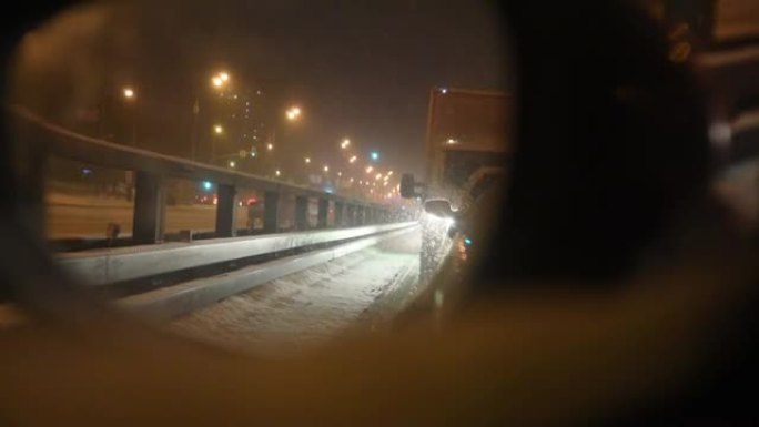 后视镜视图。大雪使交通困难。降雪导致交通堵塞。夜景