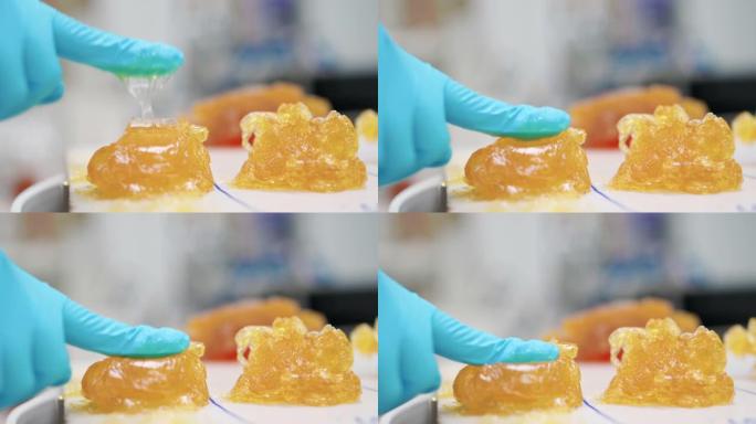 技术人员通过用手指按压在润滑脂上测试锂润滑脂NLGI 3的质地，并在实验室中查看粘性和外观。戴着丁腈