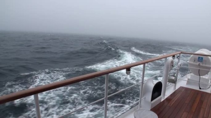 北冰洋波浪背景下的甲板游艇。