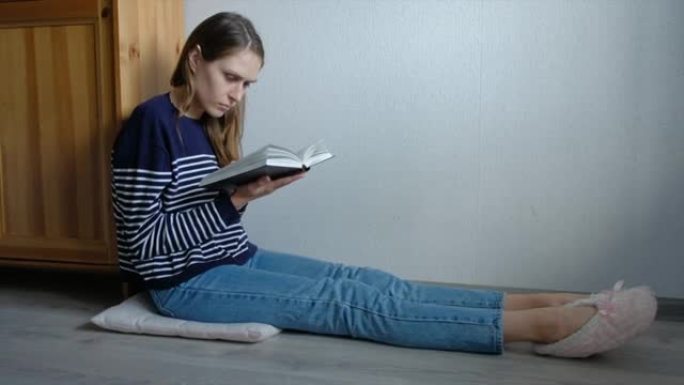 在家中的女学生坐在书架旁看书