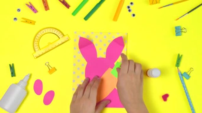 DIY和孩子们的创造力。分步说明: 用兔子和胡萝卜创建复活节卡。儿童手工复活节工艺品。顶视图。