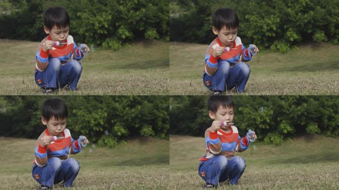 亚洲小男孩在户外玩得开心，吹泡泡