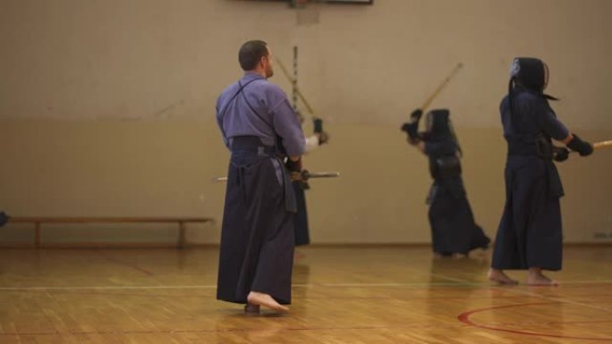 在剑道训练中，武术老师在练习决斗时观察他们的学生